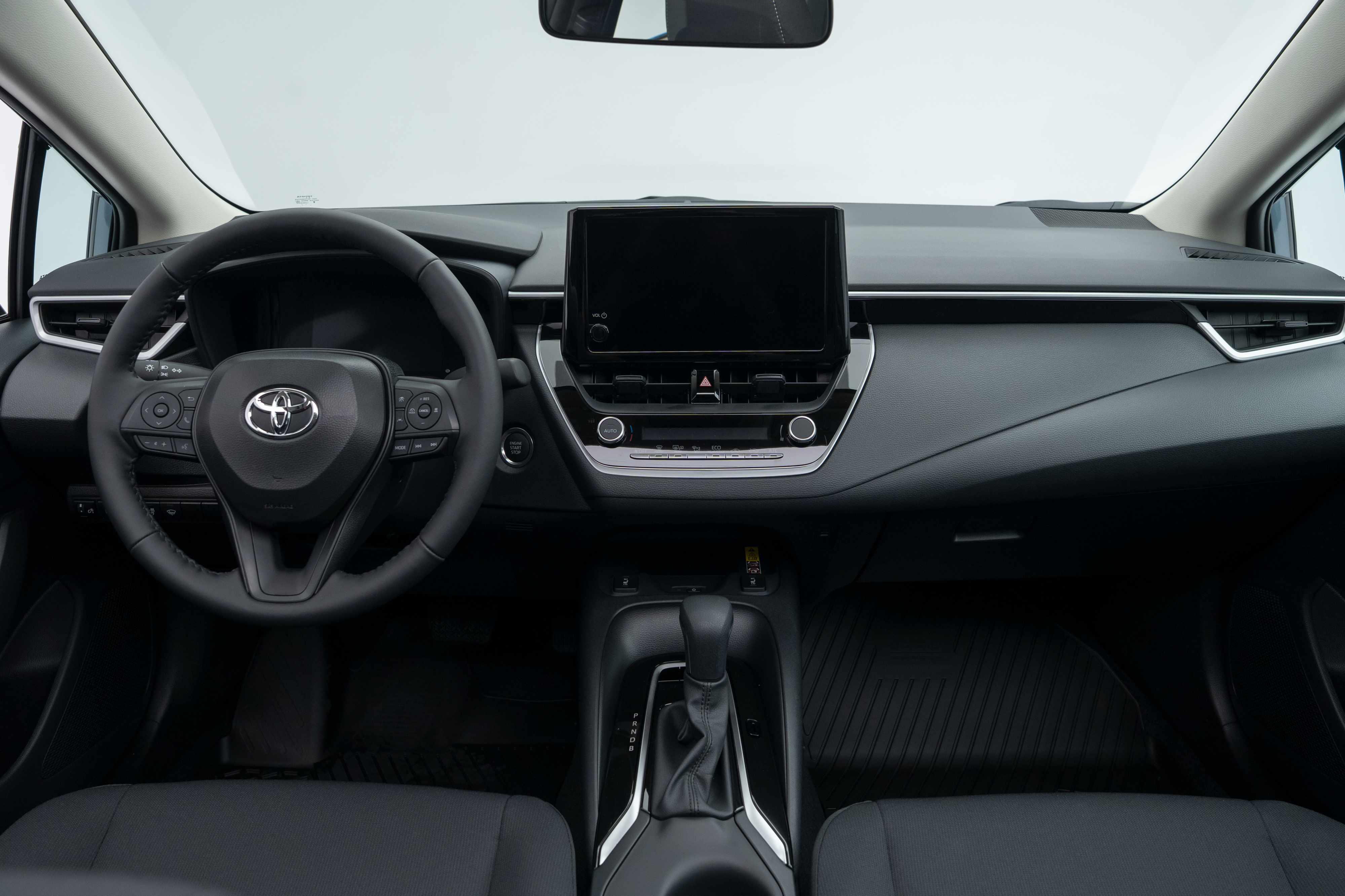 2026 Toyota Corolla interior dashboard with steering wheel, infotainment display, centre console and front seats.