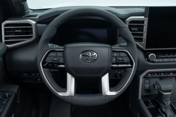 2026 Toyota Tundra steering wheel with driver controls, digital instrument display and dashboard.
