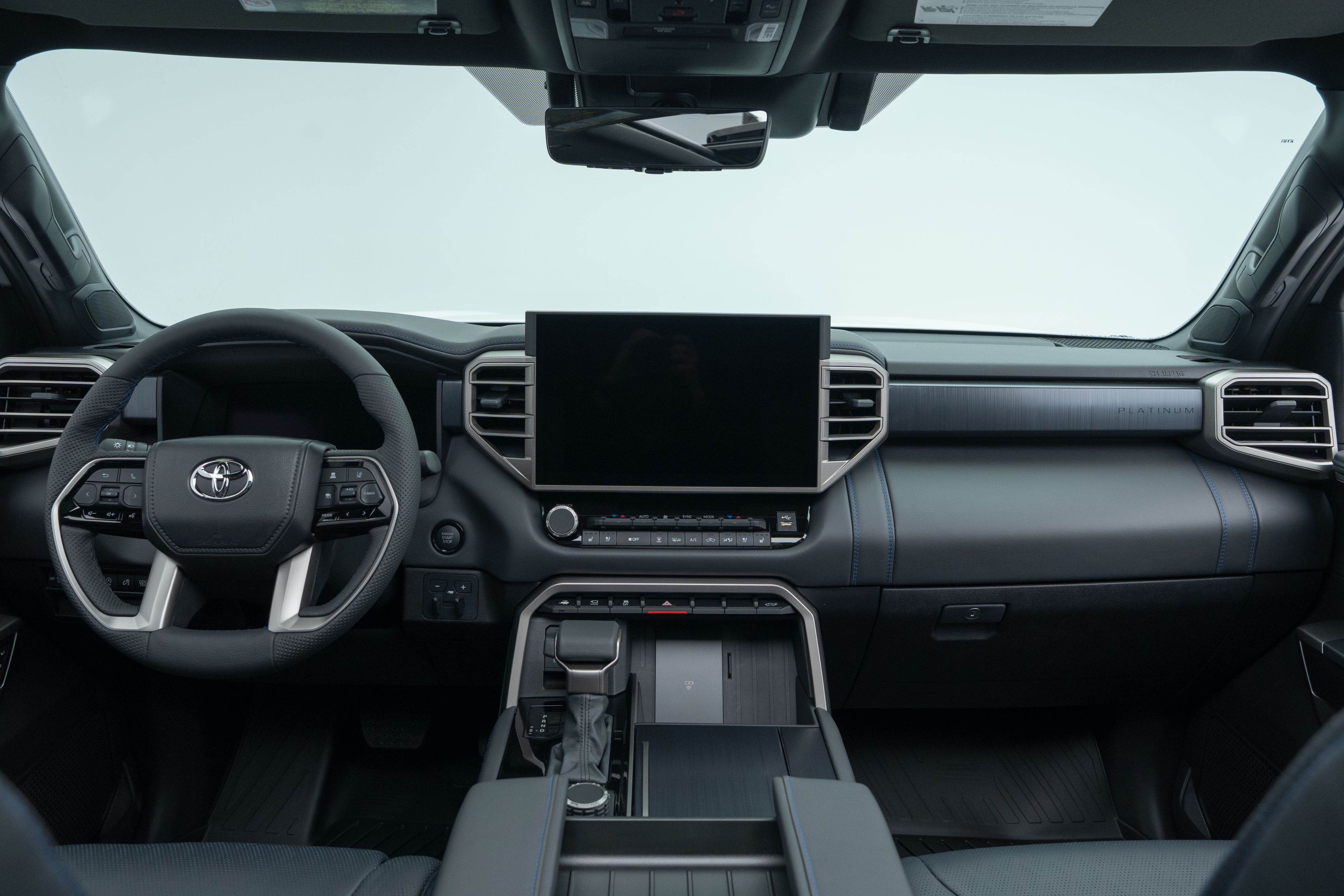 2026 Toyota Tundra interior dashboard with steering wheel, infotainment display, centre console and front seats.