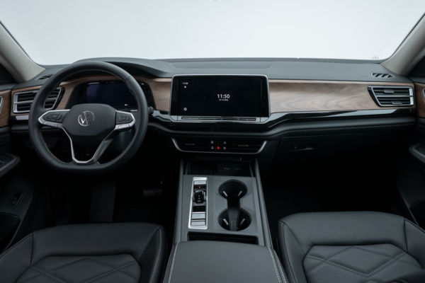 2026 Volkswagen Atlas Comfortline interior with touchscreen display, steering wheel, wood-look dashboard trim and centre console.