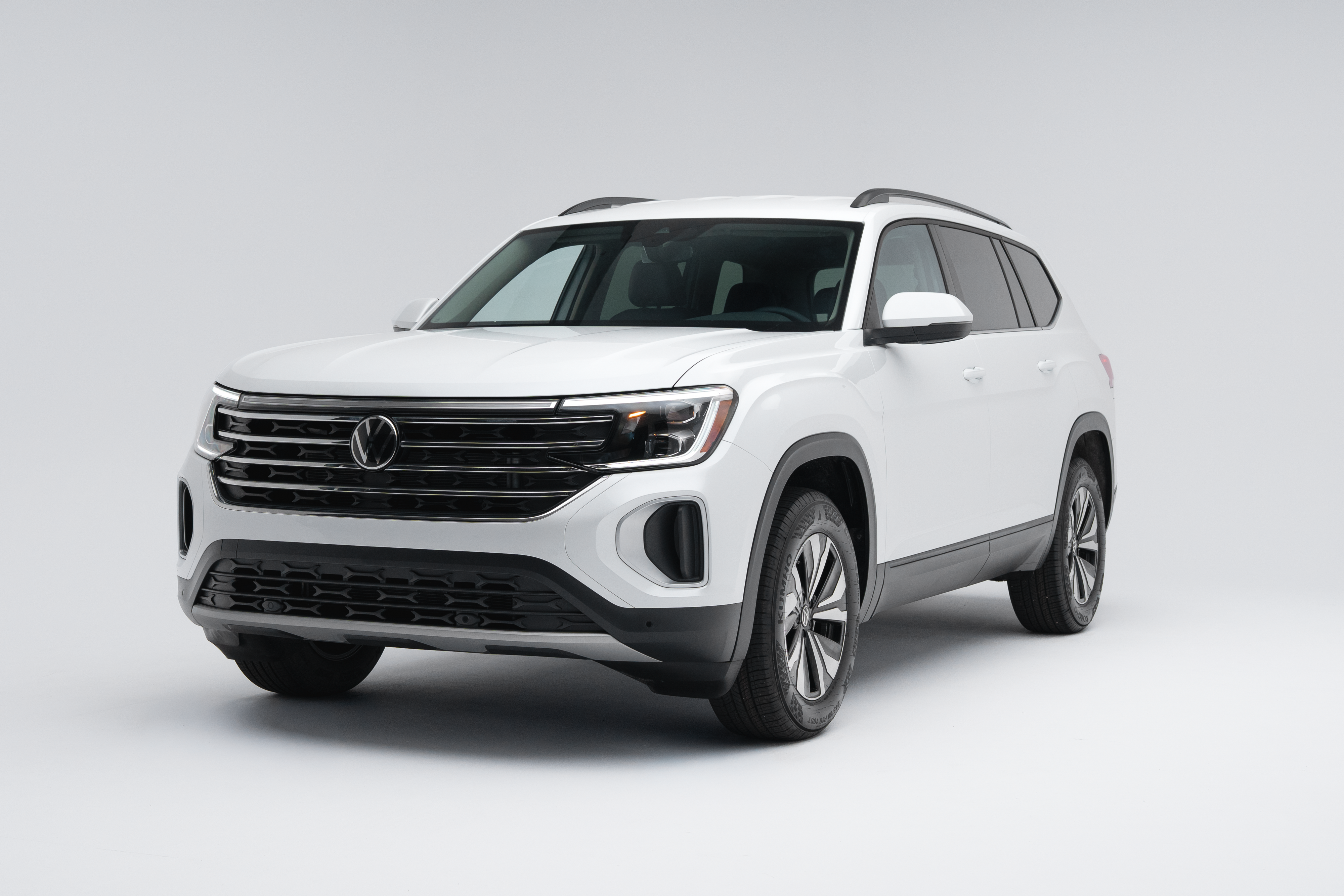 Front three-quarter view of a white 2026 Volkswagen Atlas Comfortline showing the grille, headlights and alloy wheels.