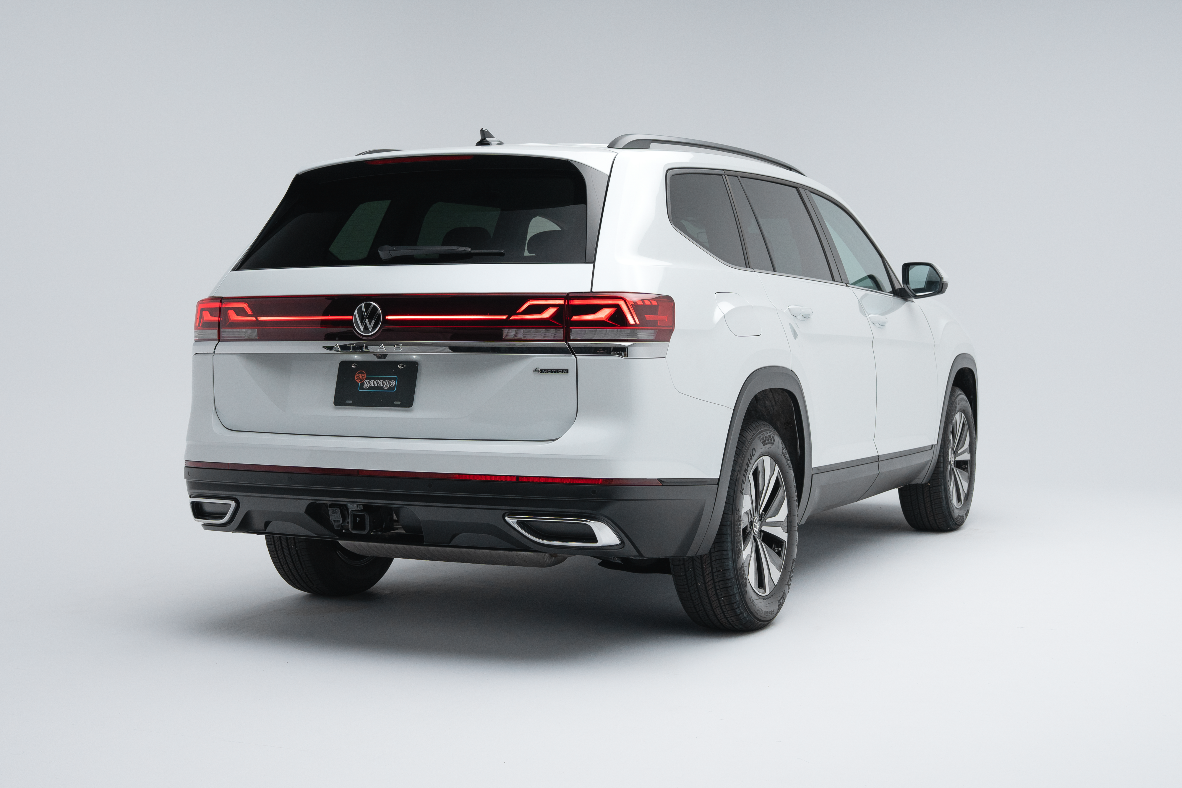 Rear three-quarter view of a white 2026 Volkswagen Atlas Comfortline showing LED taillights, alloy wheels and SUV profile.