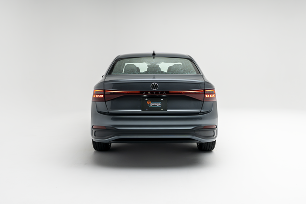 2026 Volkswagen Jetta in gray, shown from the rear with illuminated LED taillights on a white background.