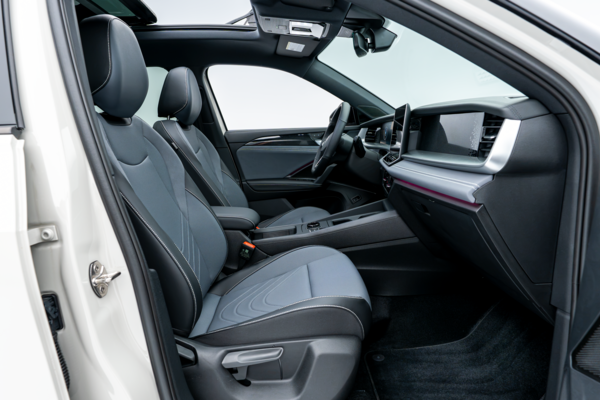 2026 Volkswagen Tiguan front interior with black seats, dashboard, centre console and panoramic sunroof.