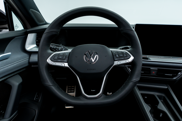 2026 Volkswagen Tiguan steering wheel with driver controls, digital instrument display and infotainment screen.