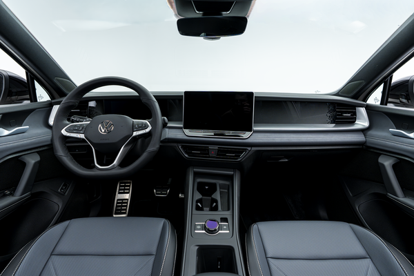 Interior view of a 2026 Volkswagen Tiguan featuring the steering wheel, digital displays, centre touchscreen, console, and front seats.