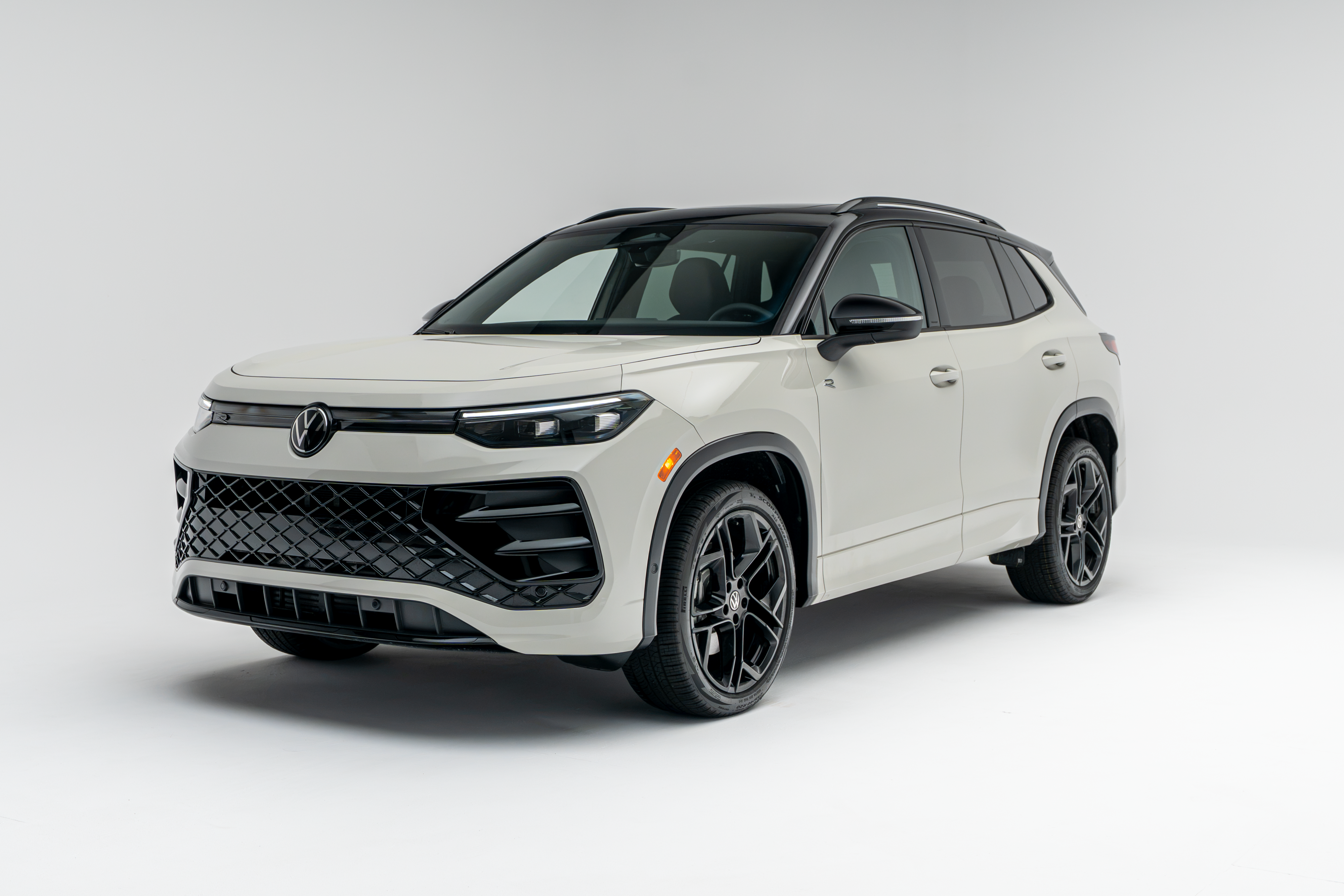 Front three-quarter view of a white 2026 Volkswagen Tiguan SUV with black wheels and trim on a white studio background.