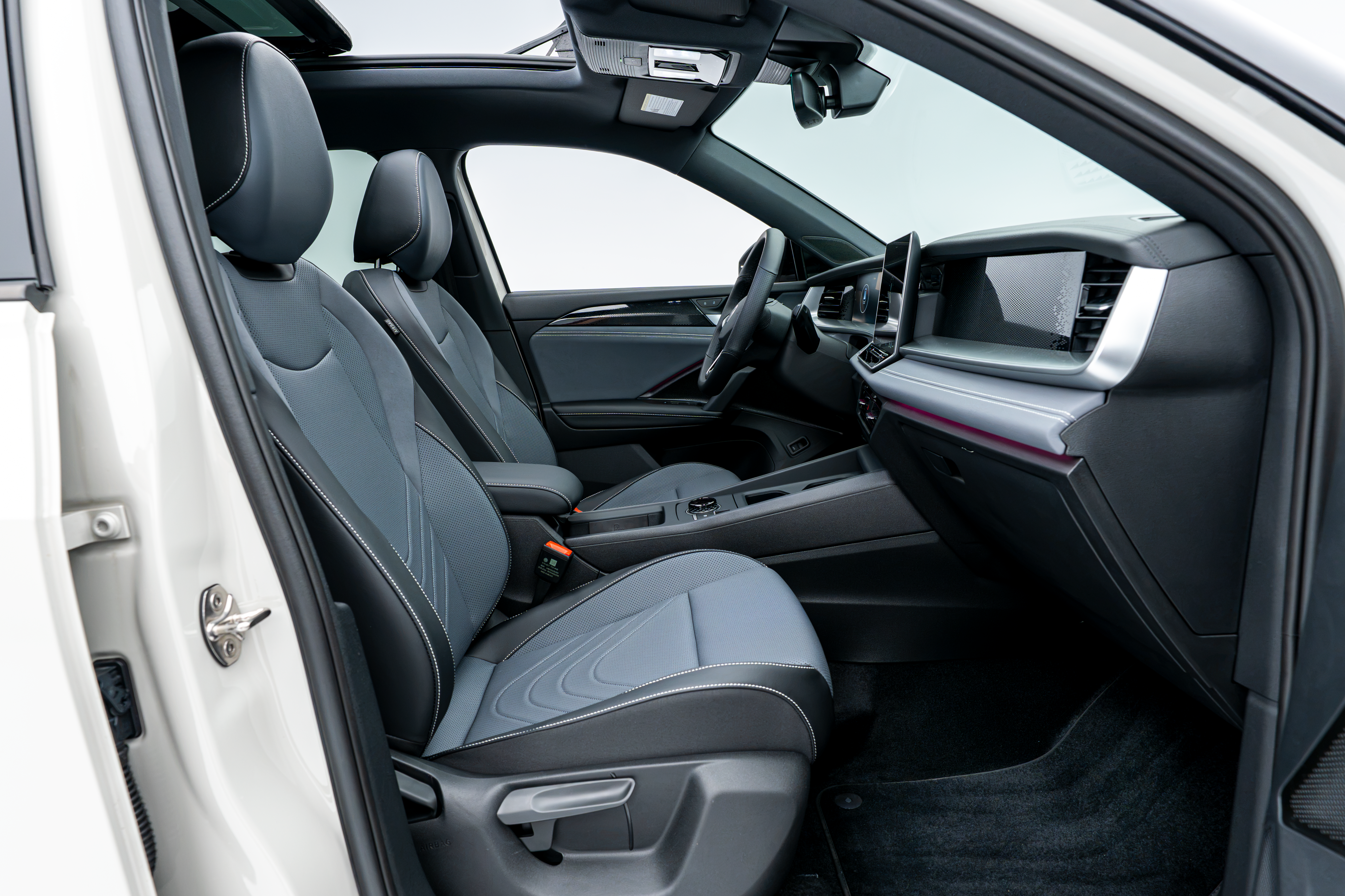 2026 Volkswagen Tiguan front interior with black seats, dashboard, centre console and panoramic sunroof.