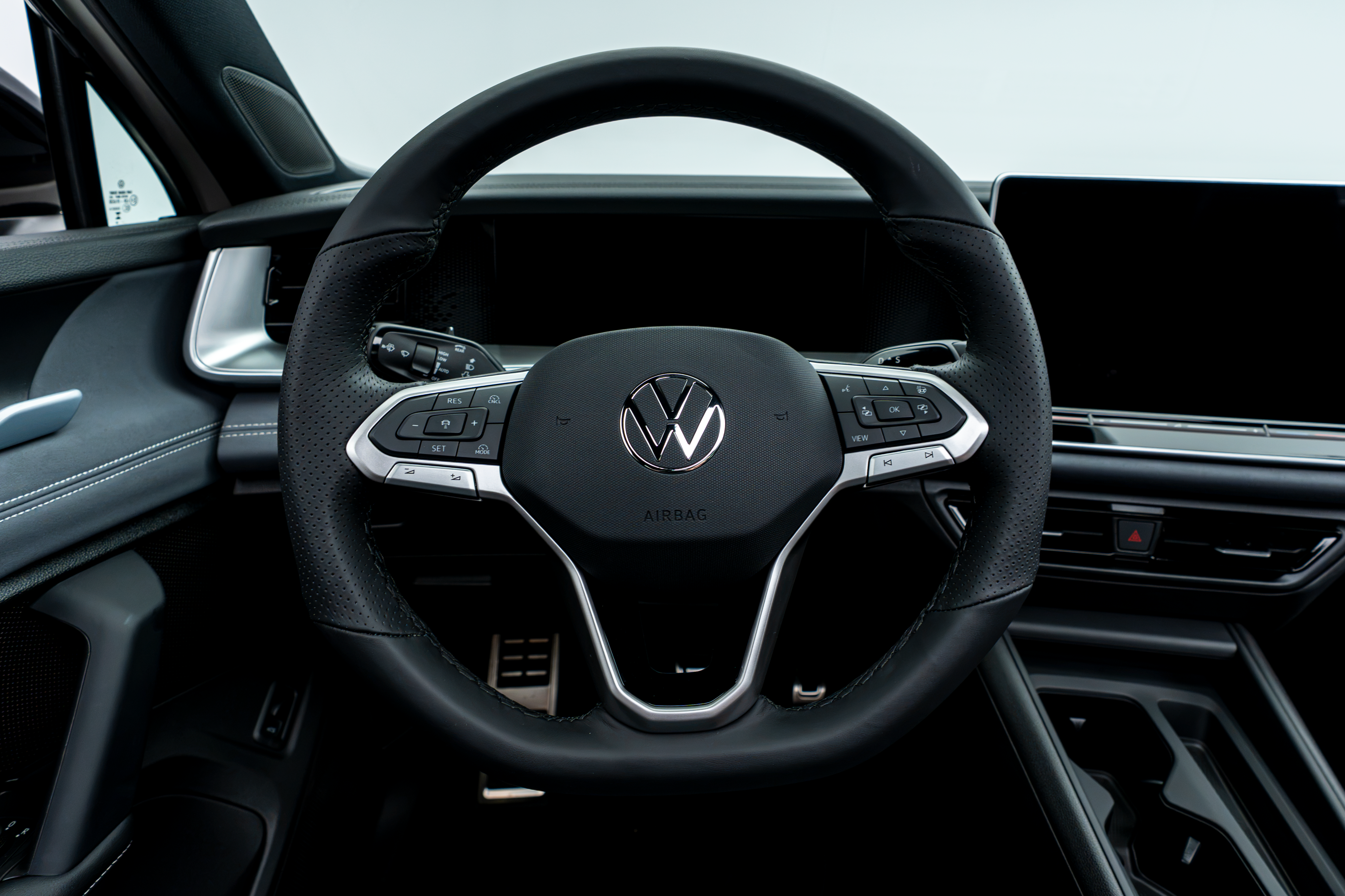 2026 Volkswagen Tiguan steering wheel with driver controls, digital instrument display and infotainment screen.