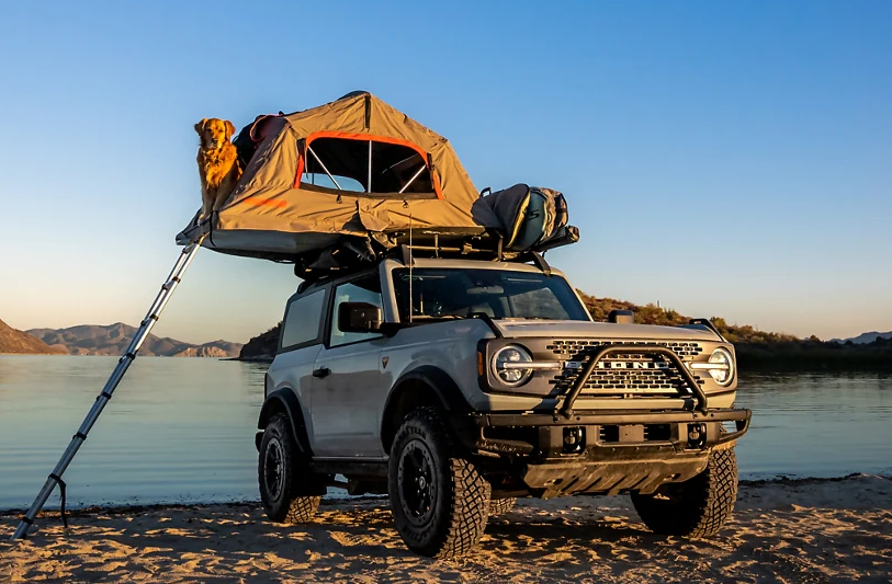 A Ford Bronco with a tent on top
