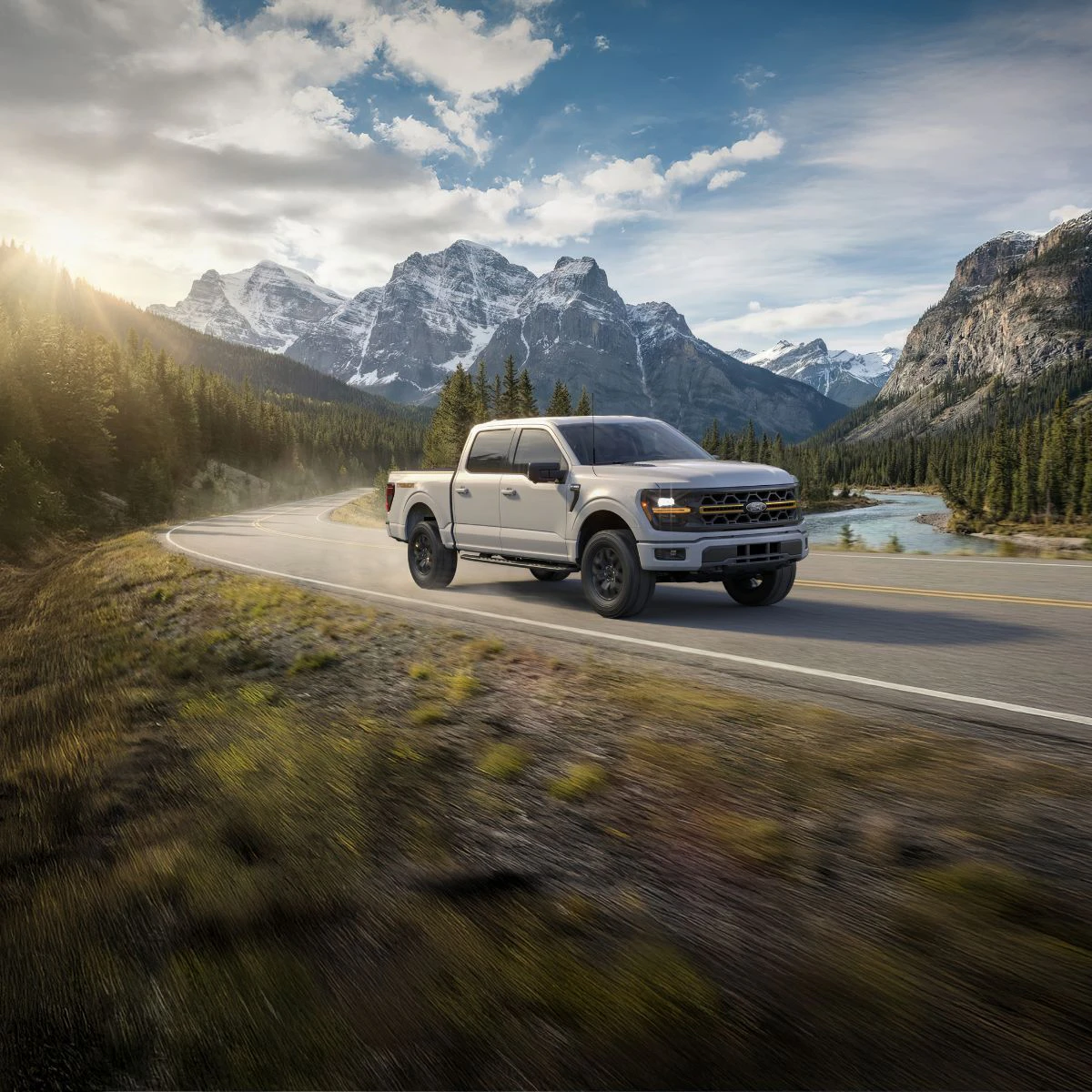 Grey F-150 driving through a mountain range.