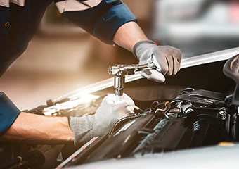 mechanic working on an engine of a vehicle