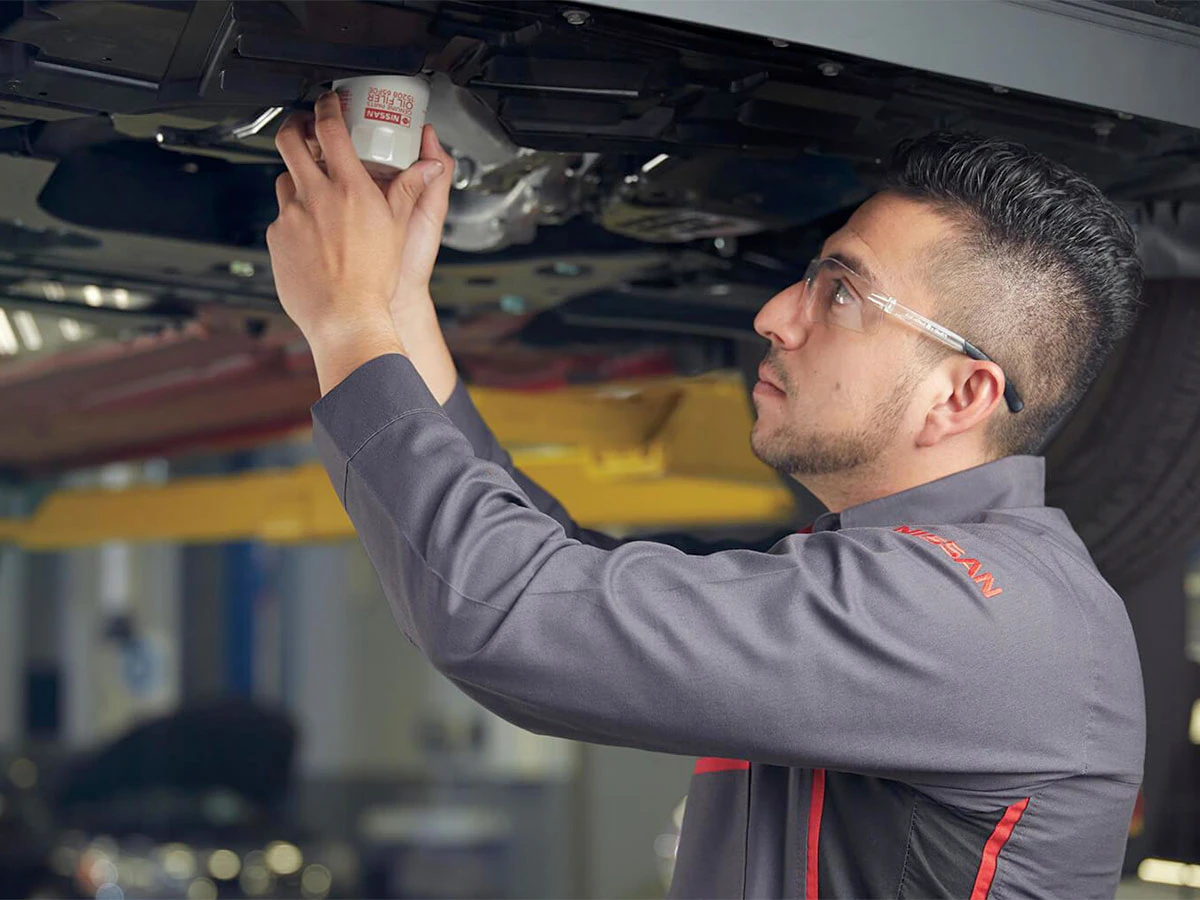Mechanic servicing Nissan cars trucks SUVs