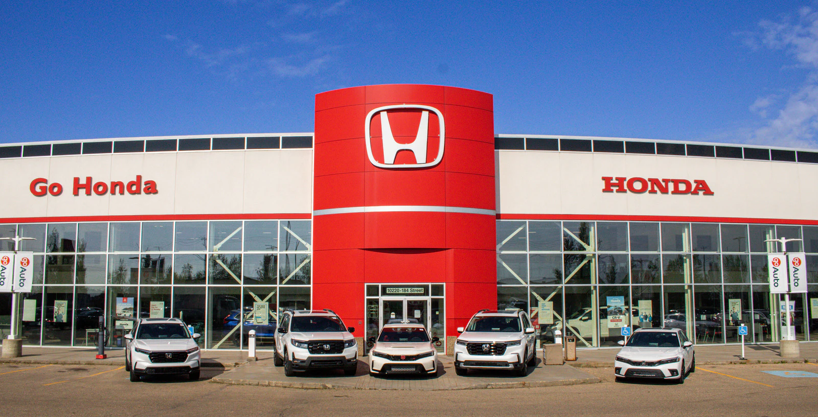 Go Honda dealership exterior with red tower and white Honda vehicles displayed in front