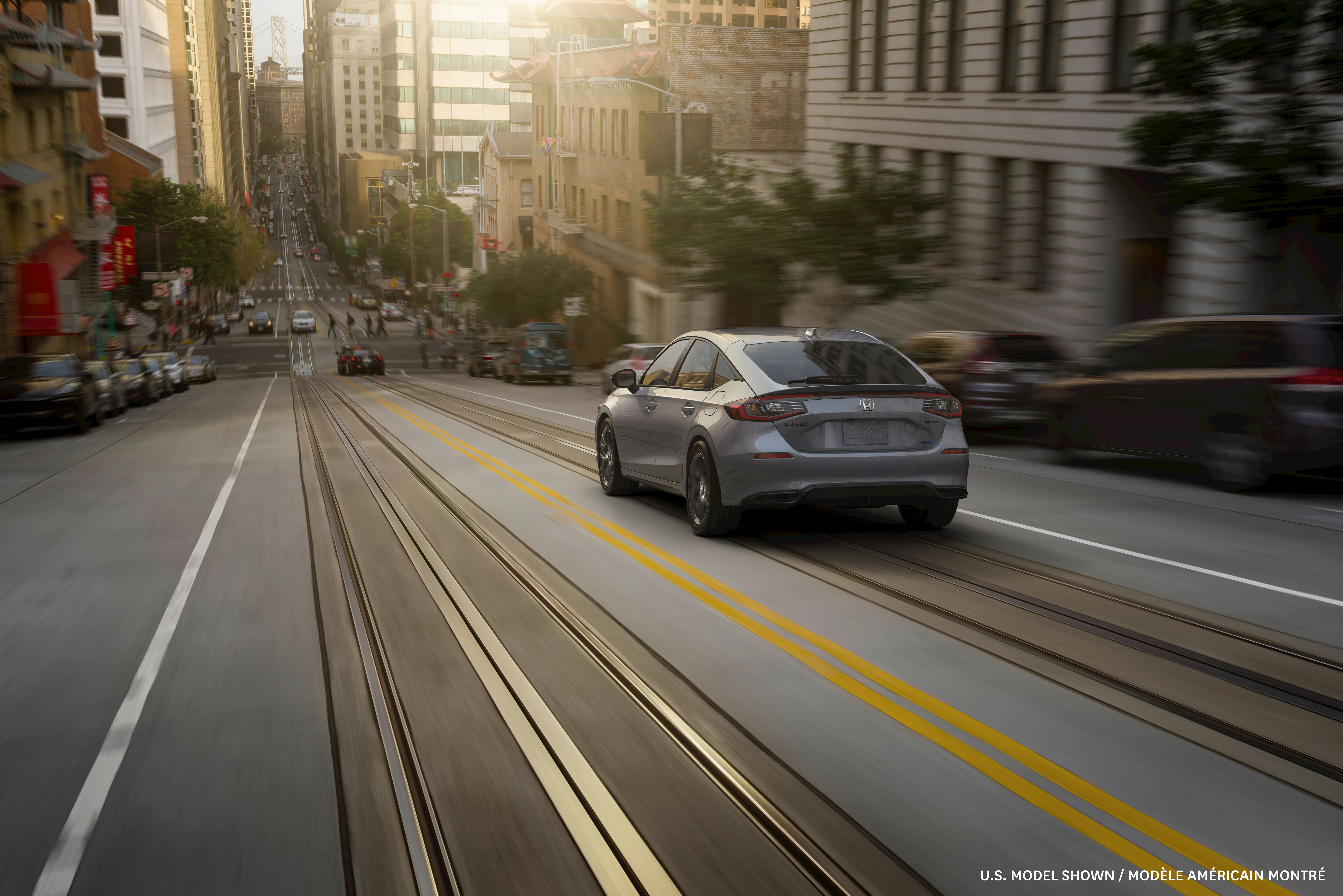 Honda Civic Hybrid travels through a bustling downtown corridor, showcasing efficient urban driving and modern design against a dynamic city backdrop.