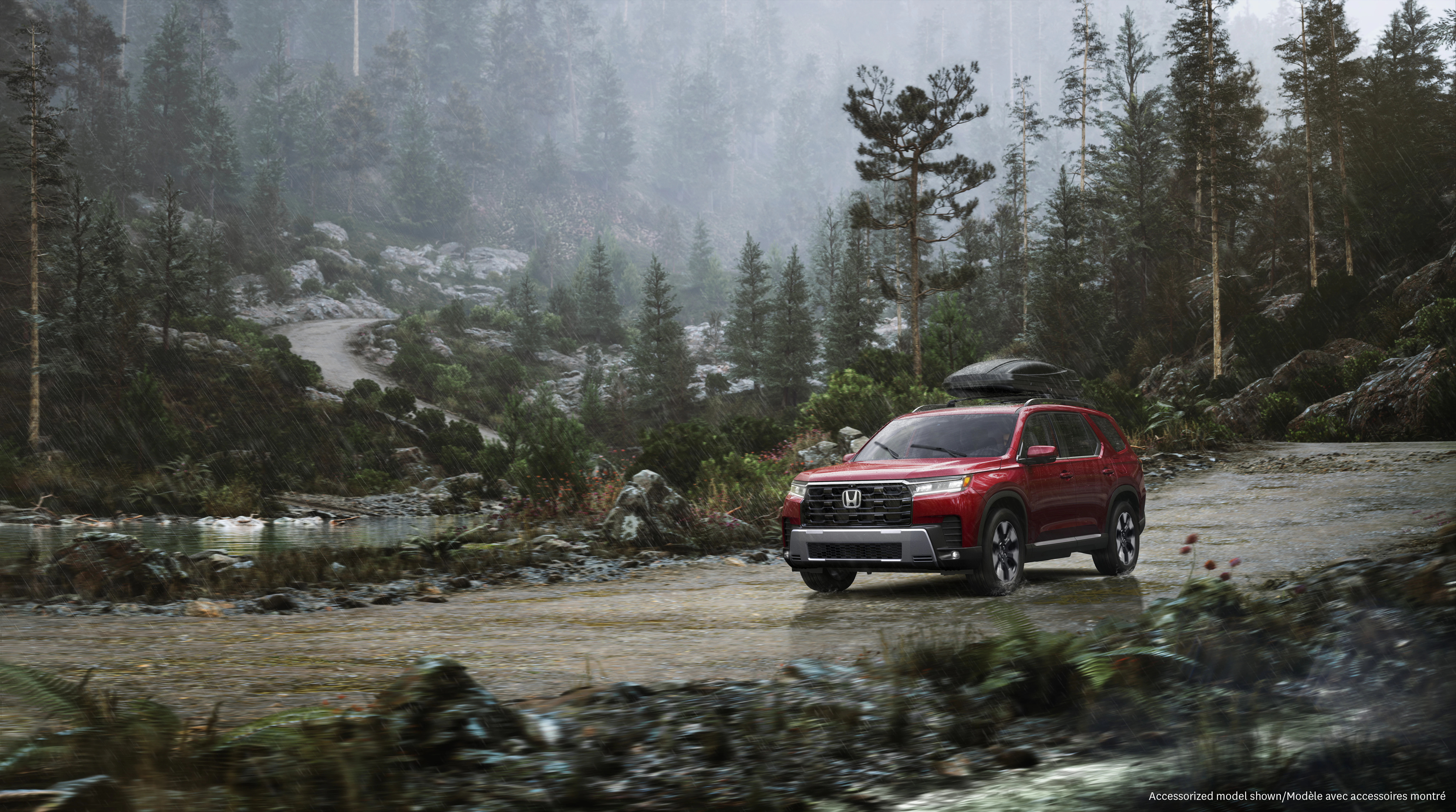 Honda Pilot navigates a rain-soaked forest trail with a rooftop cargo carrier, showcasing all-weather capability in a rugged outdoor setting.