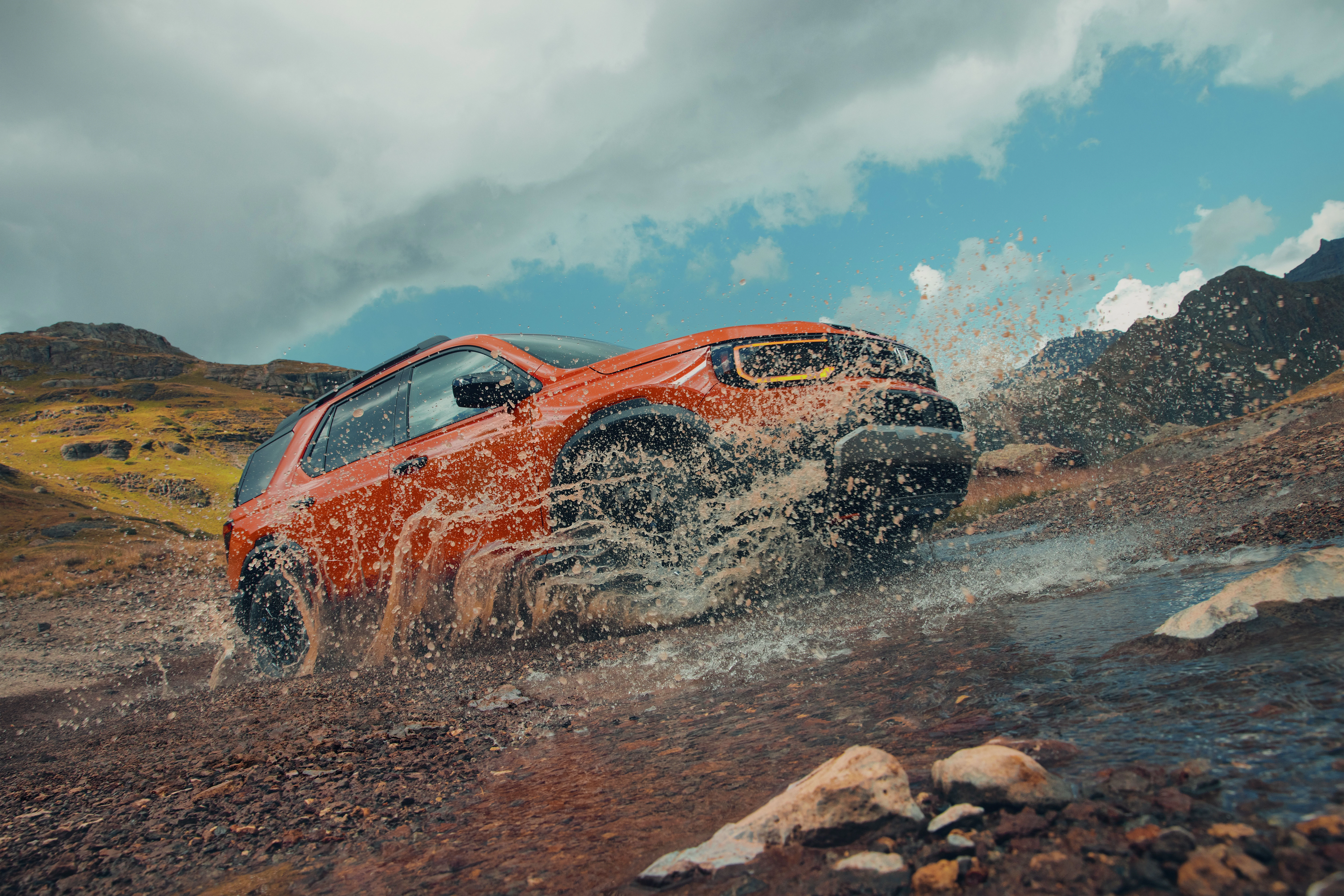 Honda Passport TrailSport powers through a mountain stream, showcasing off-road capability and adventure-ready performance in a rugged wilderness environment.