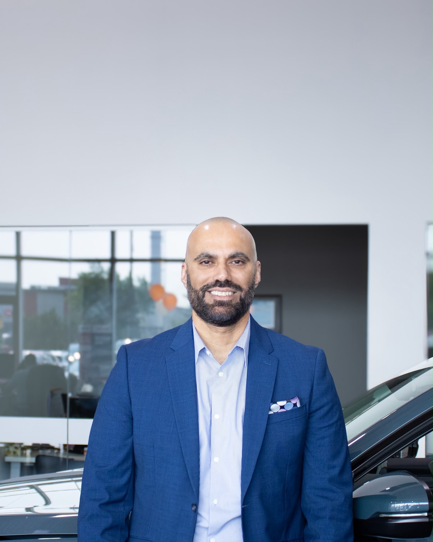 Go Auto dealership executive Harp Jawanda standing in showroom with vehicles