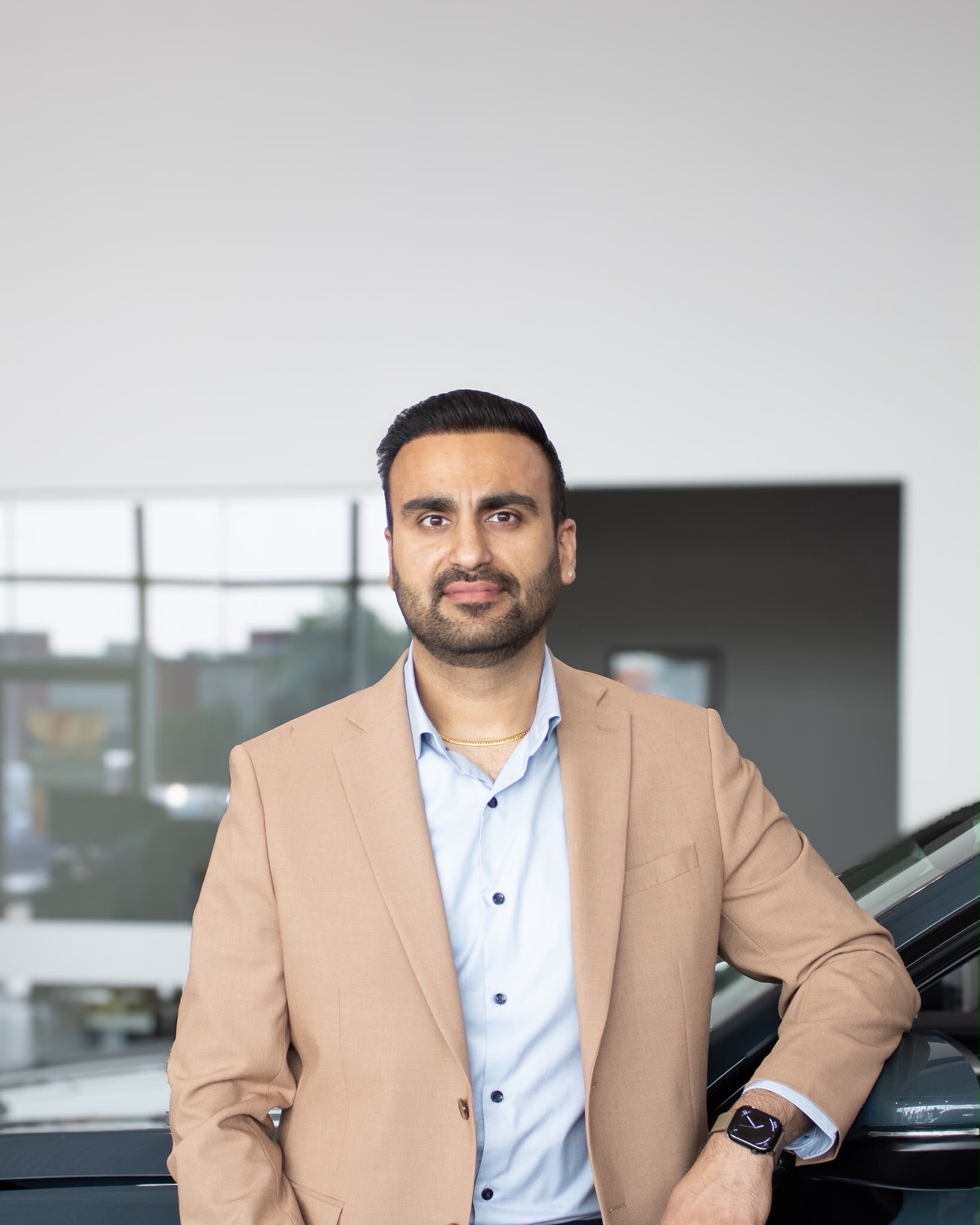 Sales professional Sahil Bagga standing next to a vehicle at Go Auto dealership