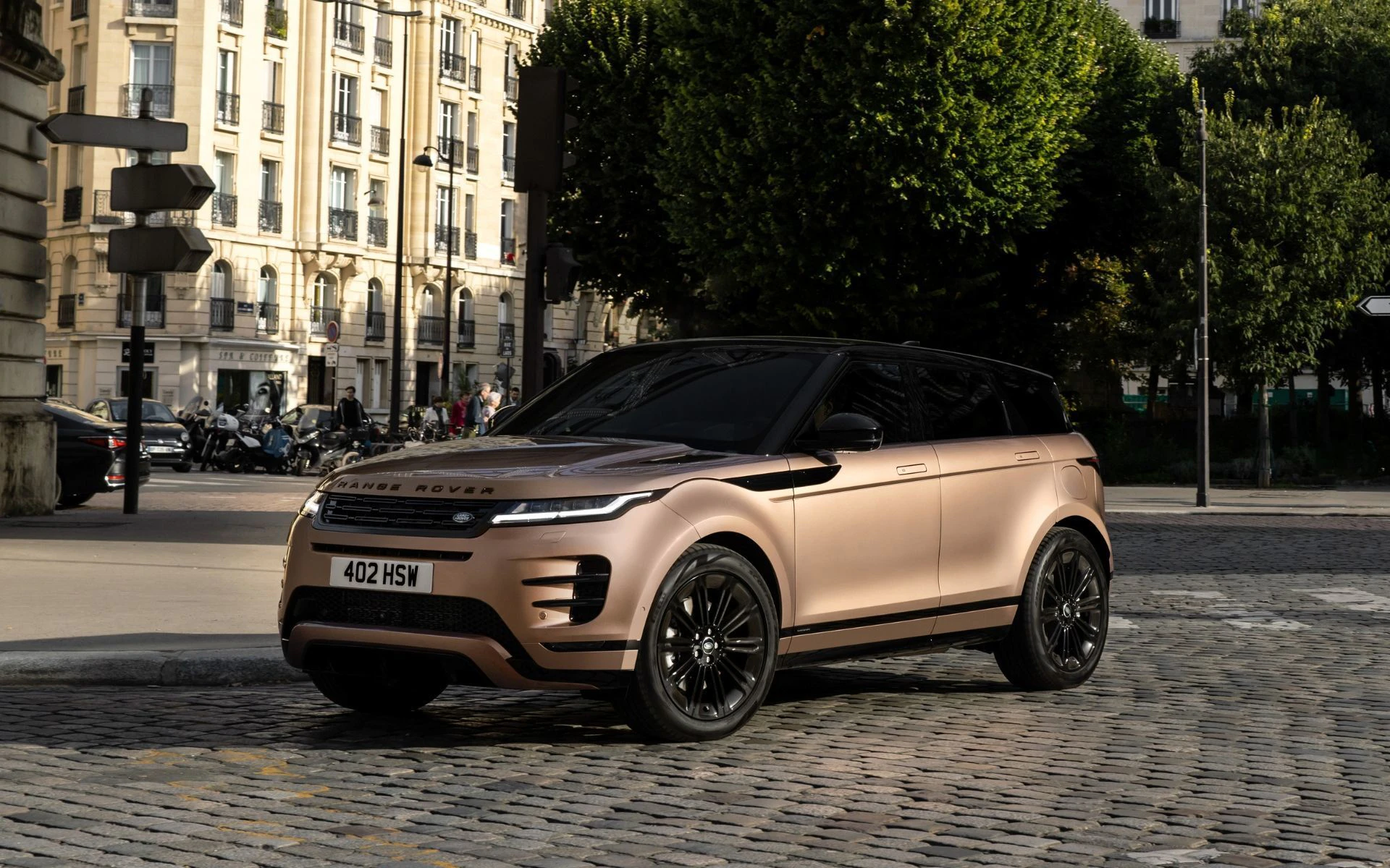 2025 Land Rover Range Evoque parked on urban street in champagne gold finish