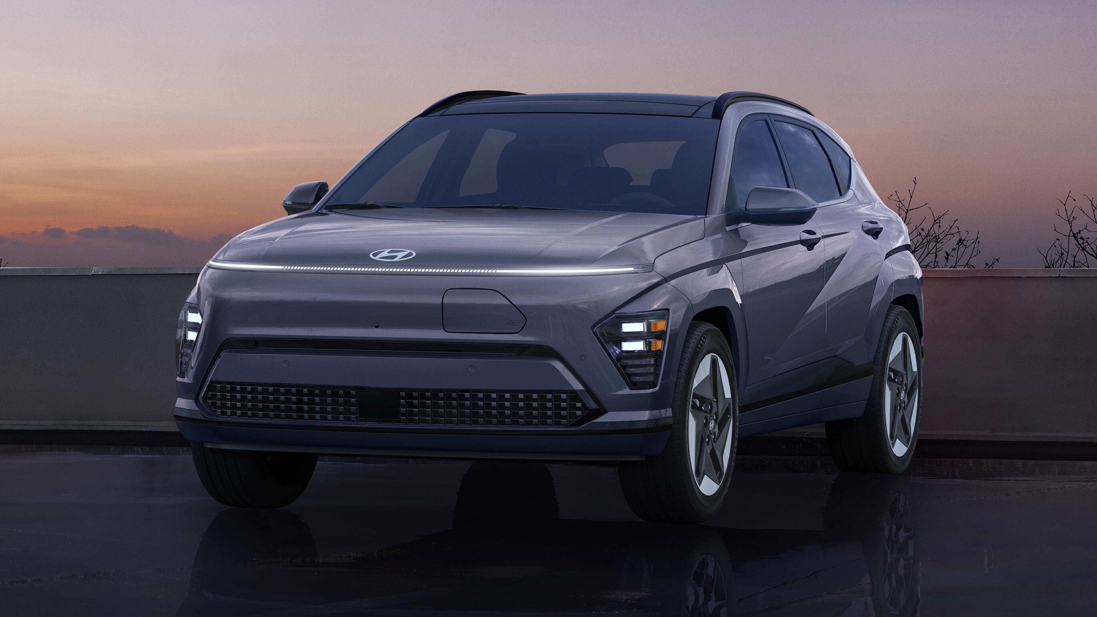 2026 Hyundai Kona Electric parked at sunset with LED headlights illuminated