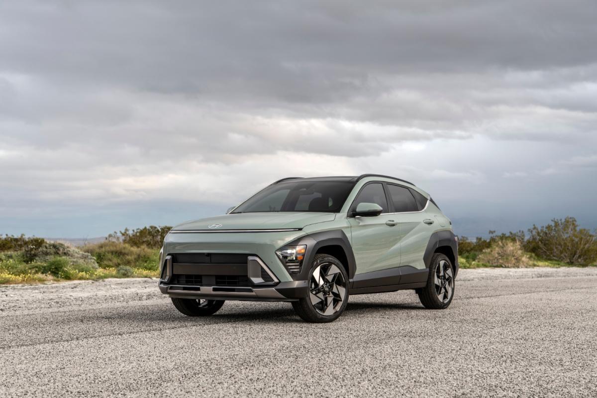 Hyundai Kona parked on desert highway with mountains in background