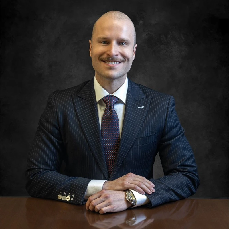 Man in pinstriped suit and tie at desk, professional headshot