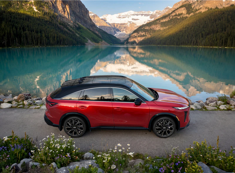 Red 2026 Infiniti QX65 parked at Lake Louise with snow-capped mountains and turquoise water in background