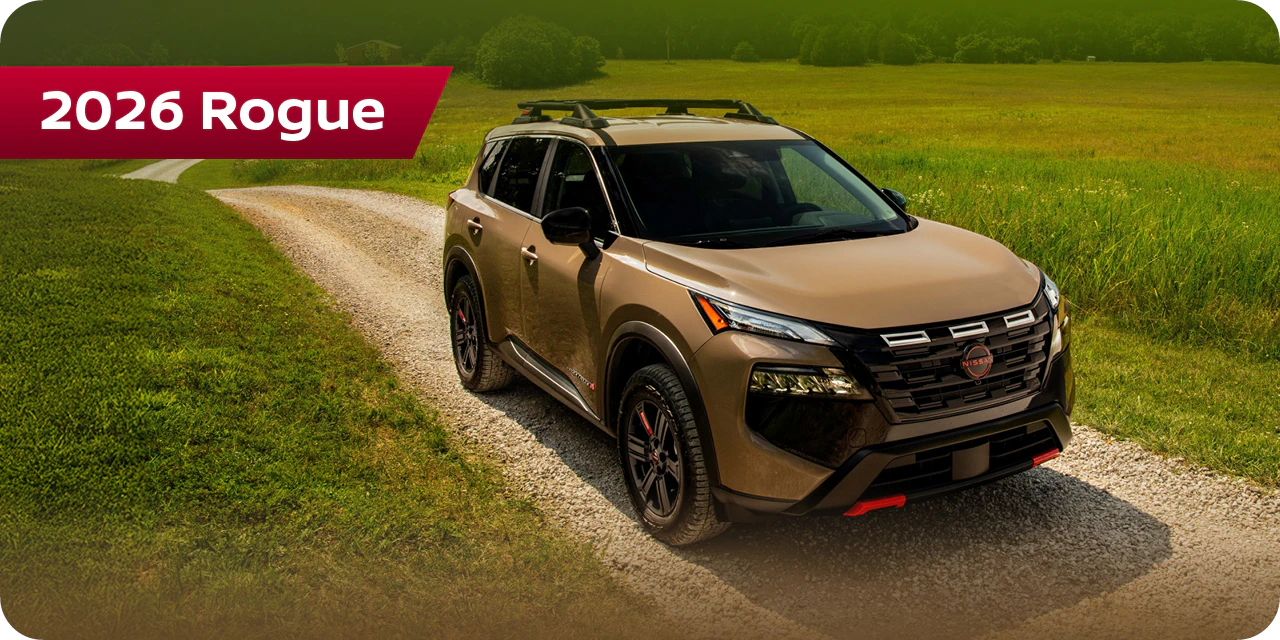 2026 Nissan Rogue parked on gravel driveway with green field background