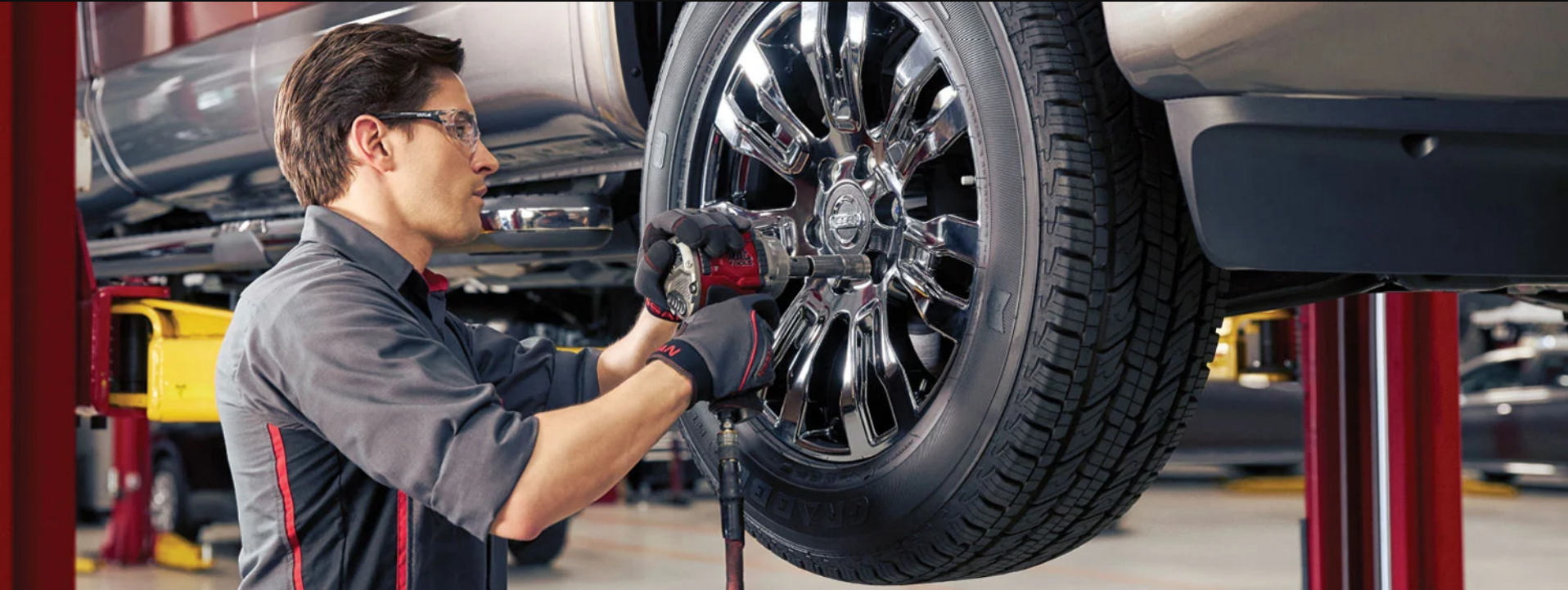 car mechanic servicing a vehicle tire in the shop