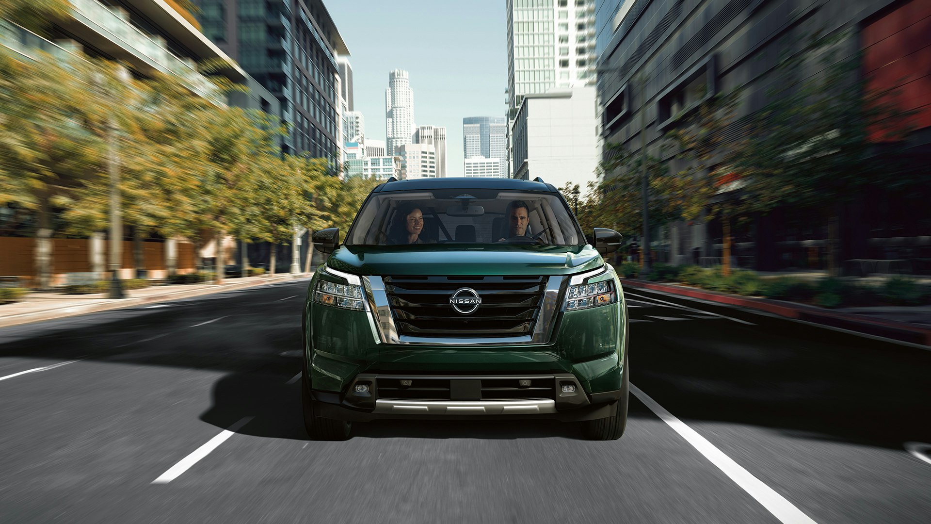 couple driving a nissan in the city