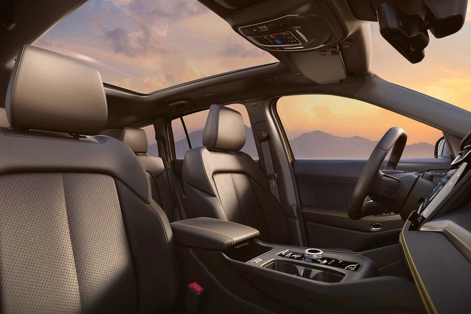 2026 Jeep Cherokee interior with panoramic sunroof framing sunset mountain view