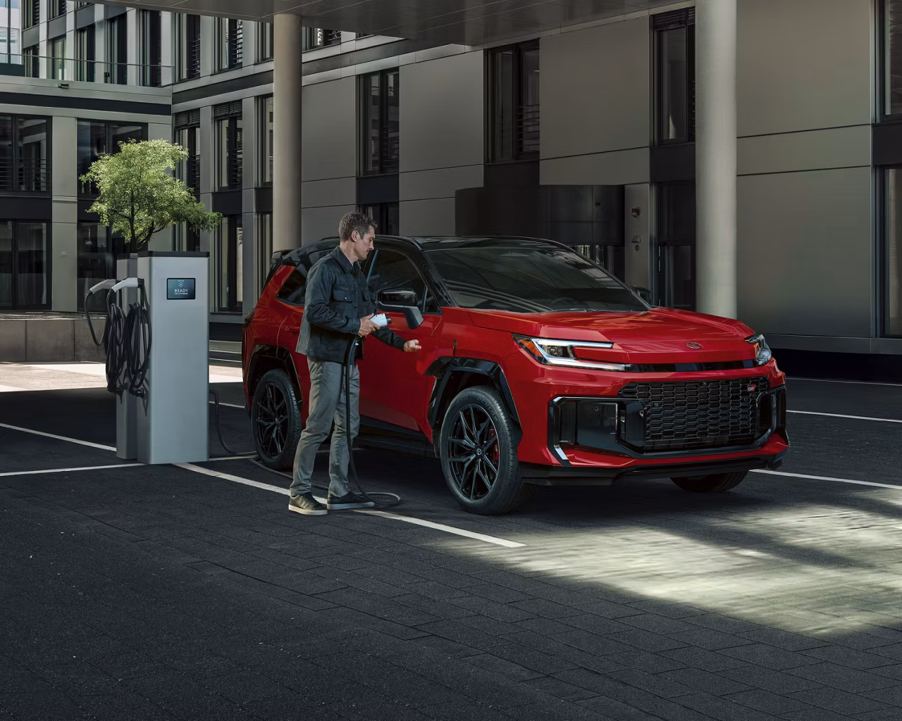 Toyota 2026 red RAV4 Plug-In Hybrid at charging station