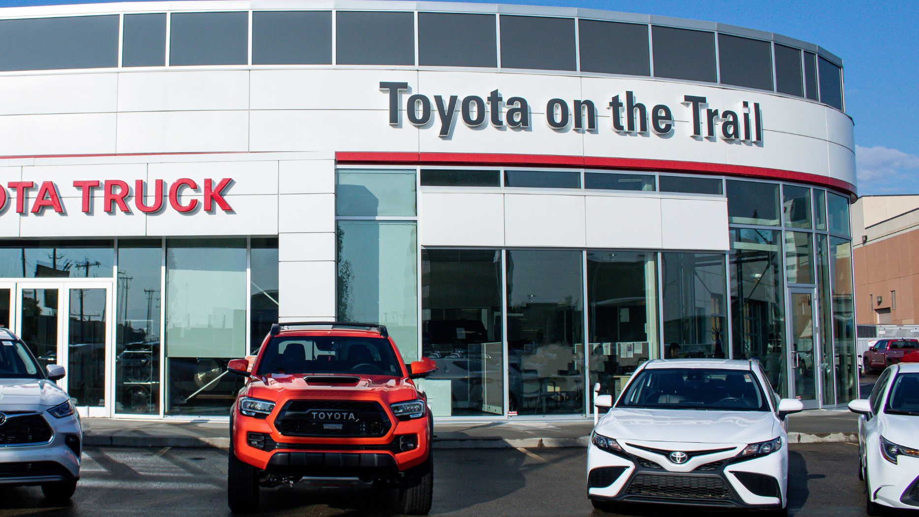 The outside of Toyota on the Trail car dealership in Edmonton. It has multiple Toyotas parked in front of it.