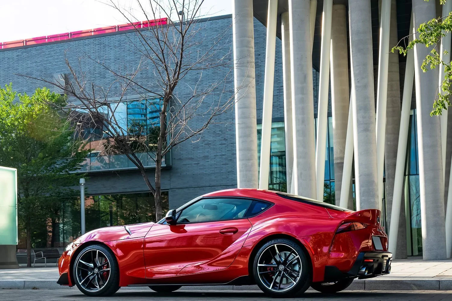 A red Toyota parked outside of a building