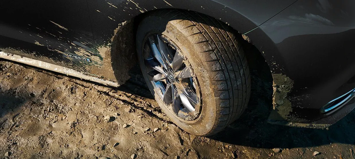 A close up of Toyota Sienna wheel driving in dirt