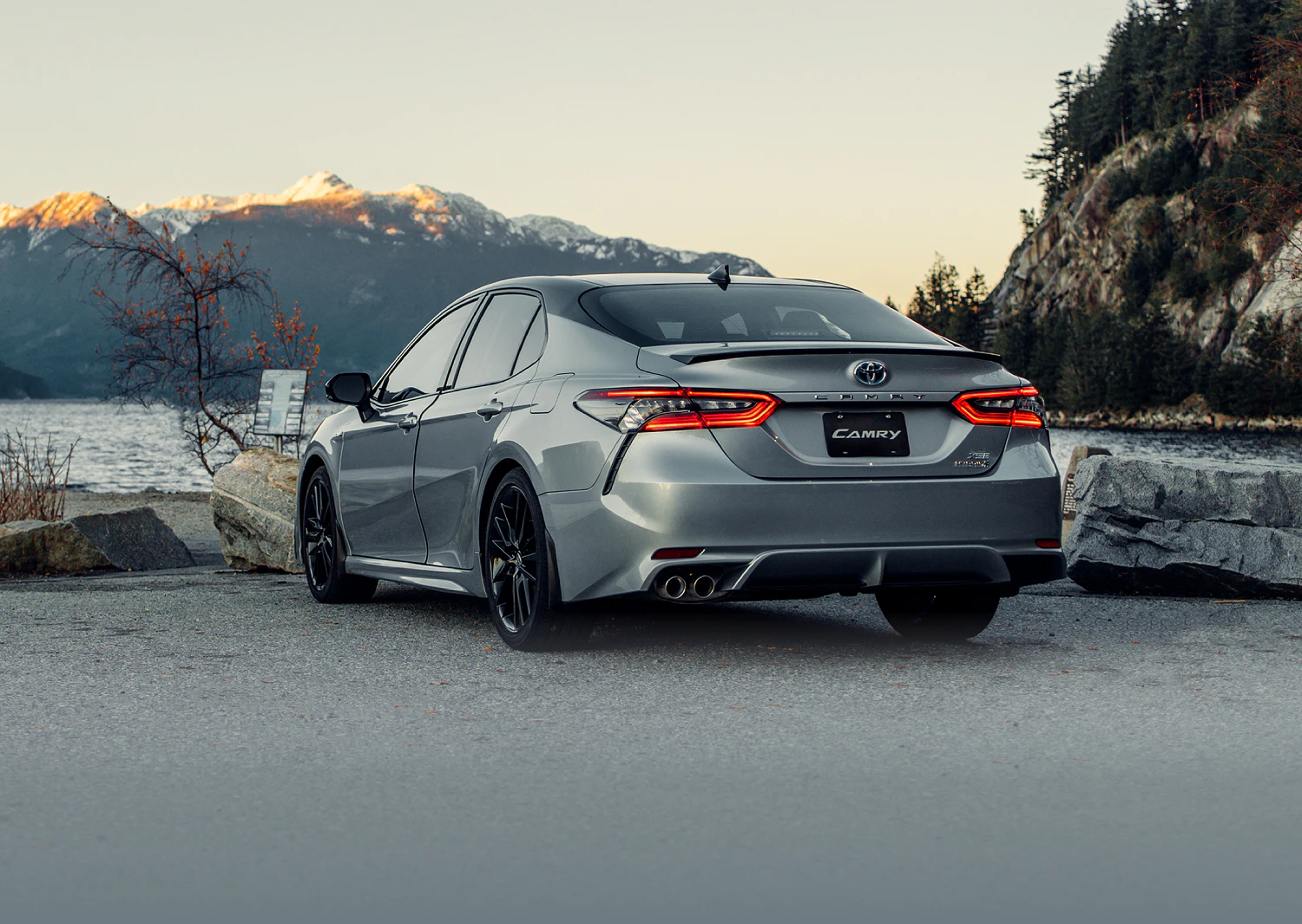 Rear end of a Toyota vehicle. The background is a mountain sunset.