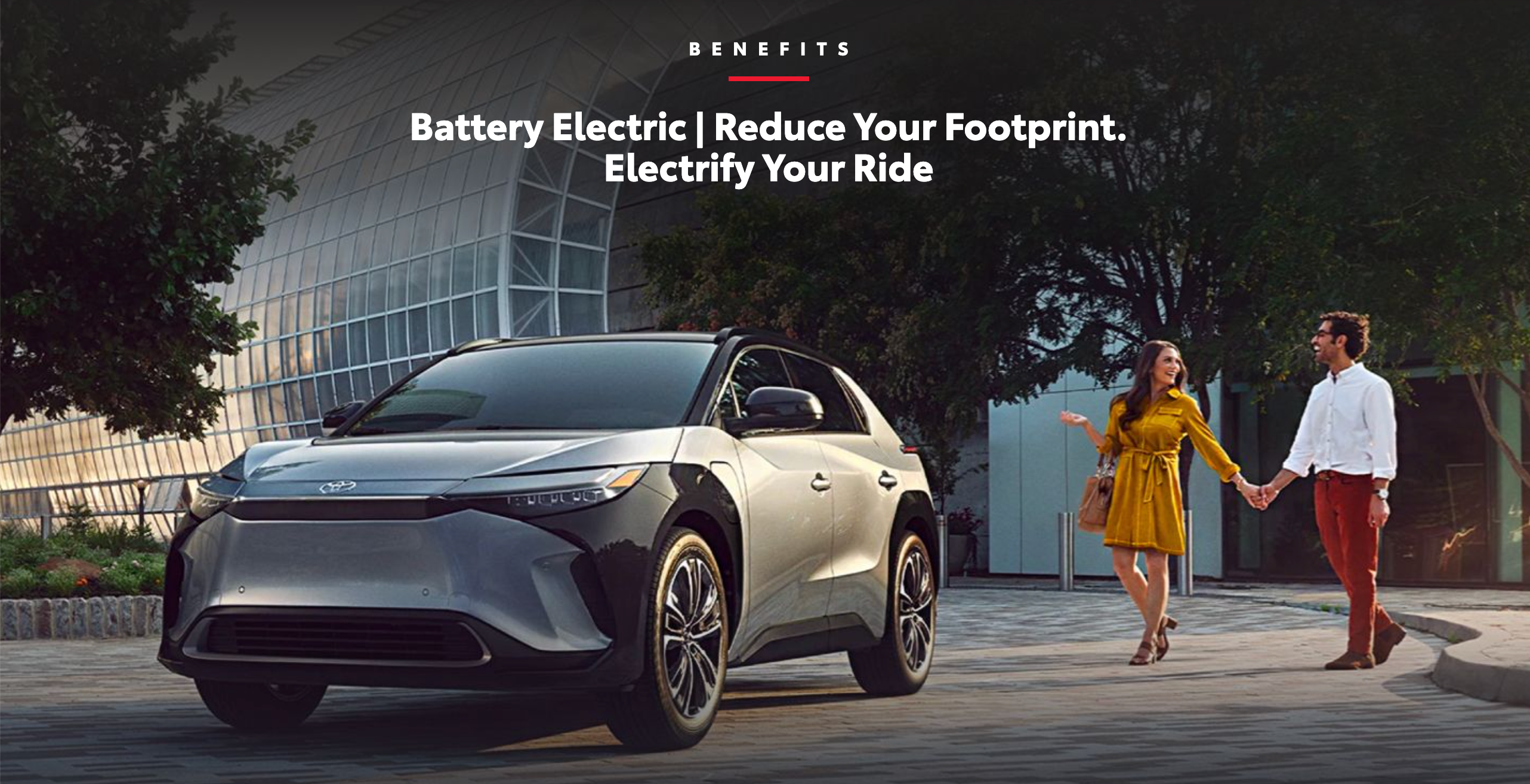 Benefits of Battery Electric | Reduce Your Footprint, Electrify your Ride. A couple holding hands walking towards their electric Toyota.
