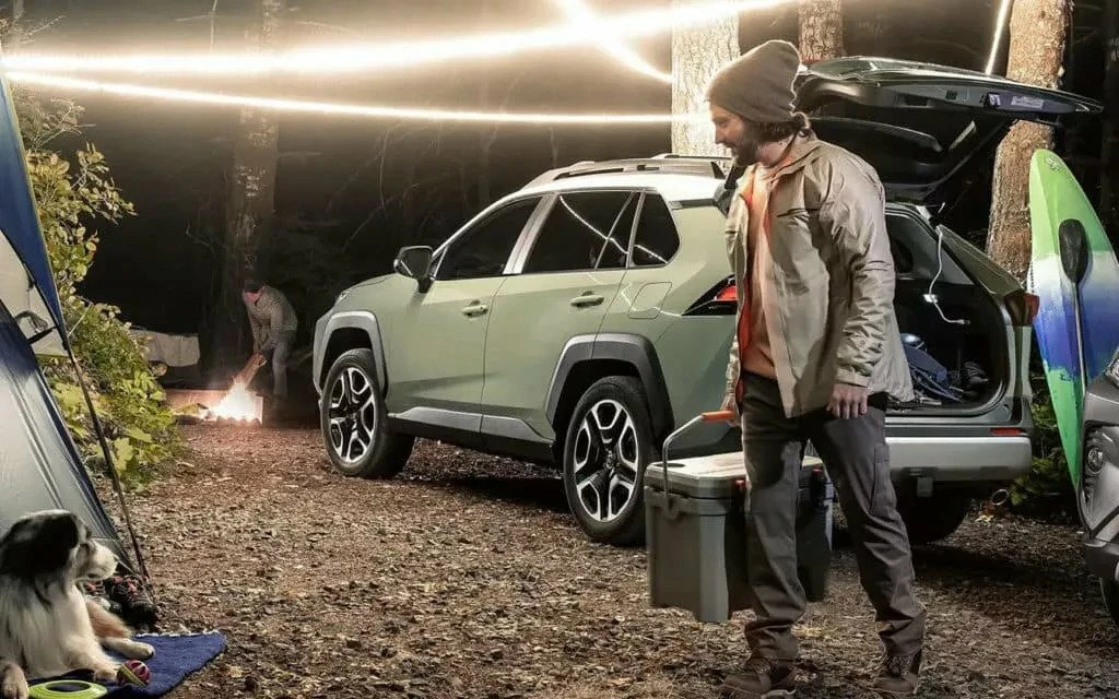 Trunk of Toyota SUV open with people preparing for a camping trip