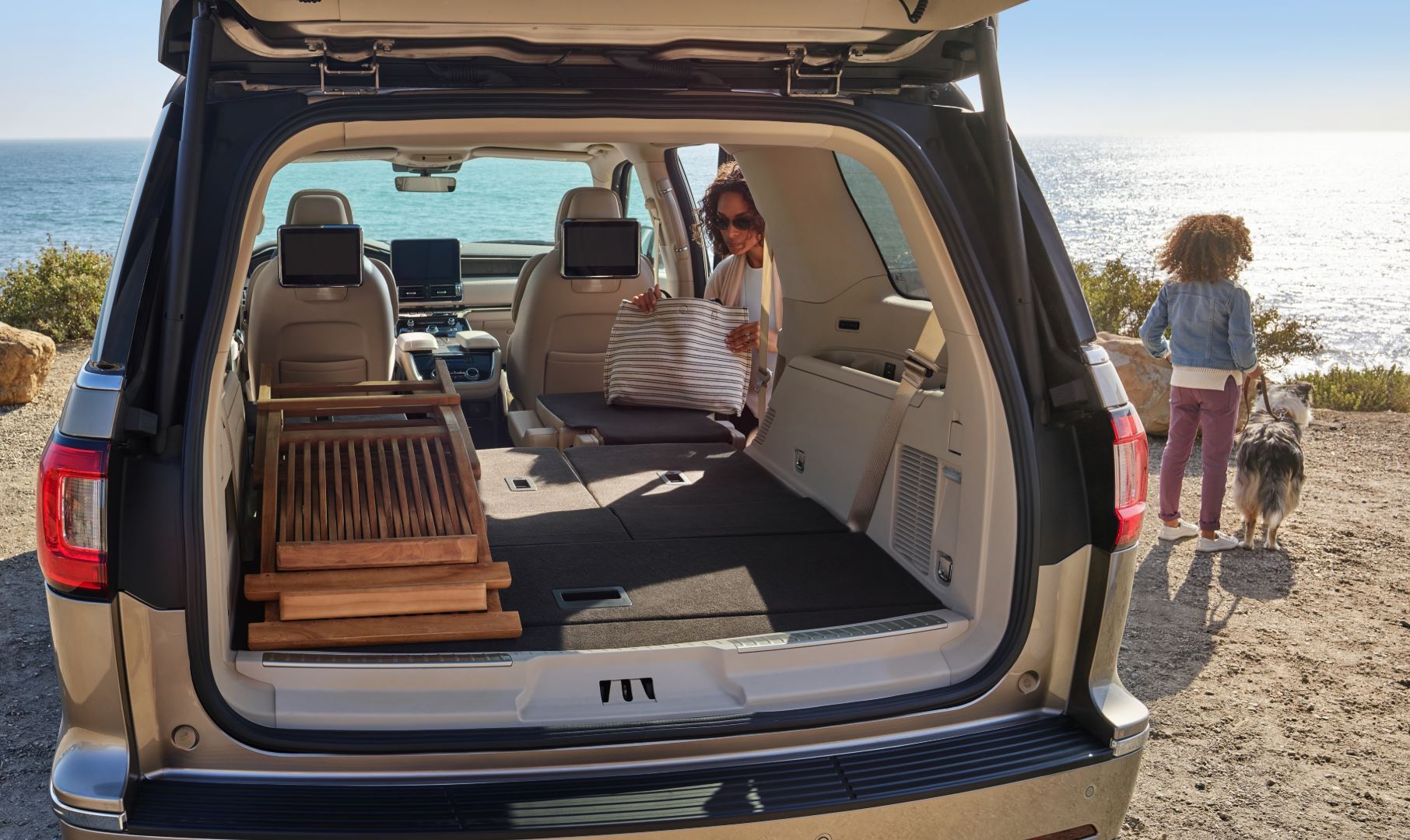 Ford SUV with open rear hatch showing spacious cargo area at beach with family nearby