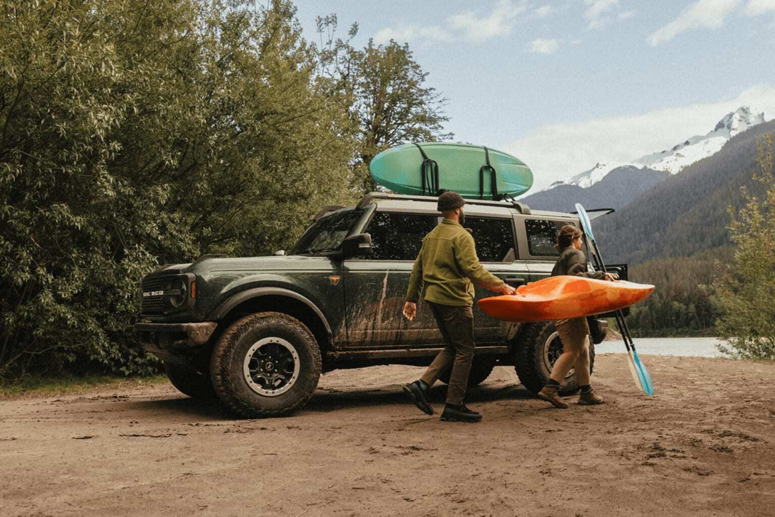 Ford Bronco with kayaks and gear ready for outdoor adventure at mountain lakeside