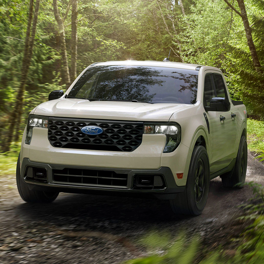 2026 Ford Maverick compact pickup truck driving on wooded forest road