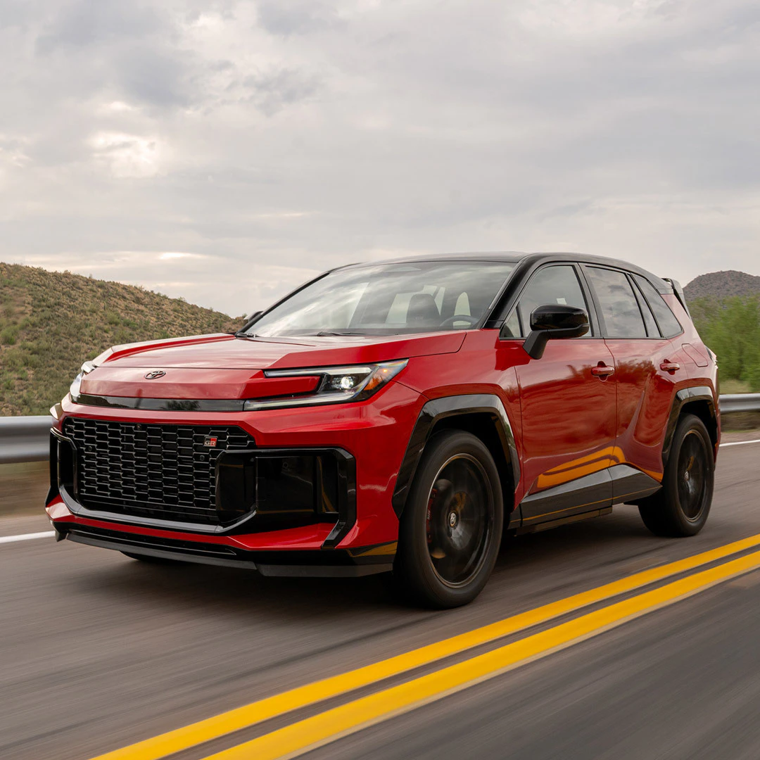 2026 Toyota RAV4 GR Sport red compact SUV driving on highway with desert hills in background