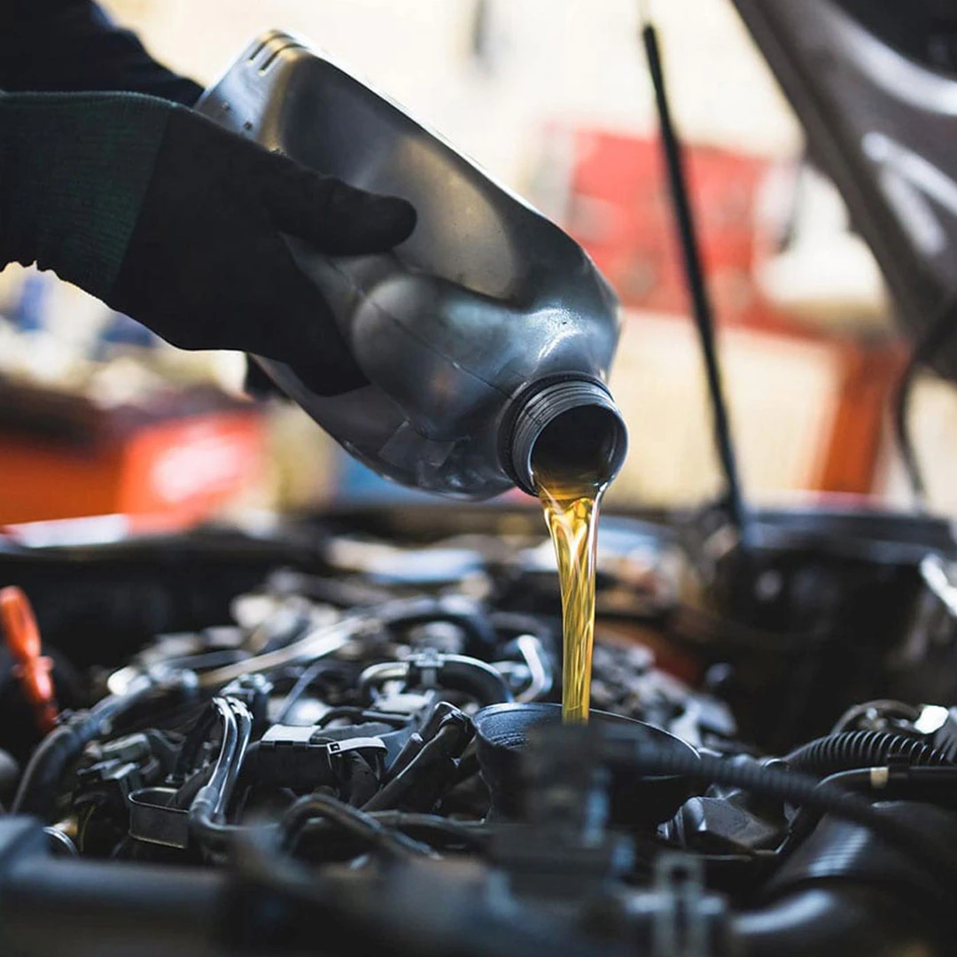 Technician pouring fresh oil into Hyundai engine during service