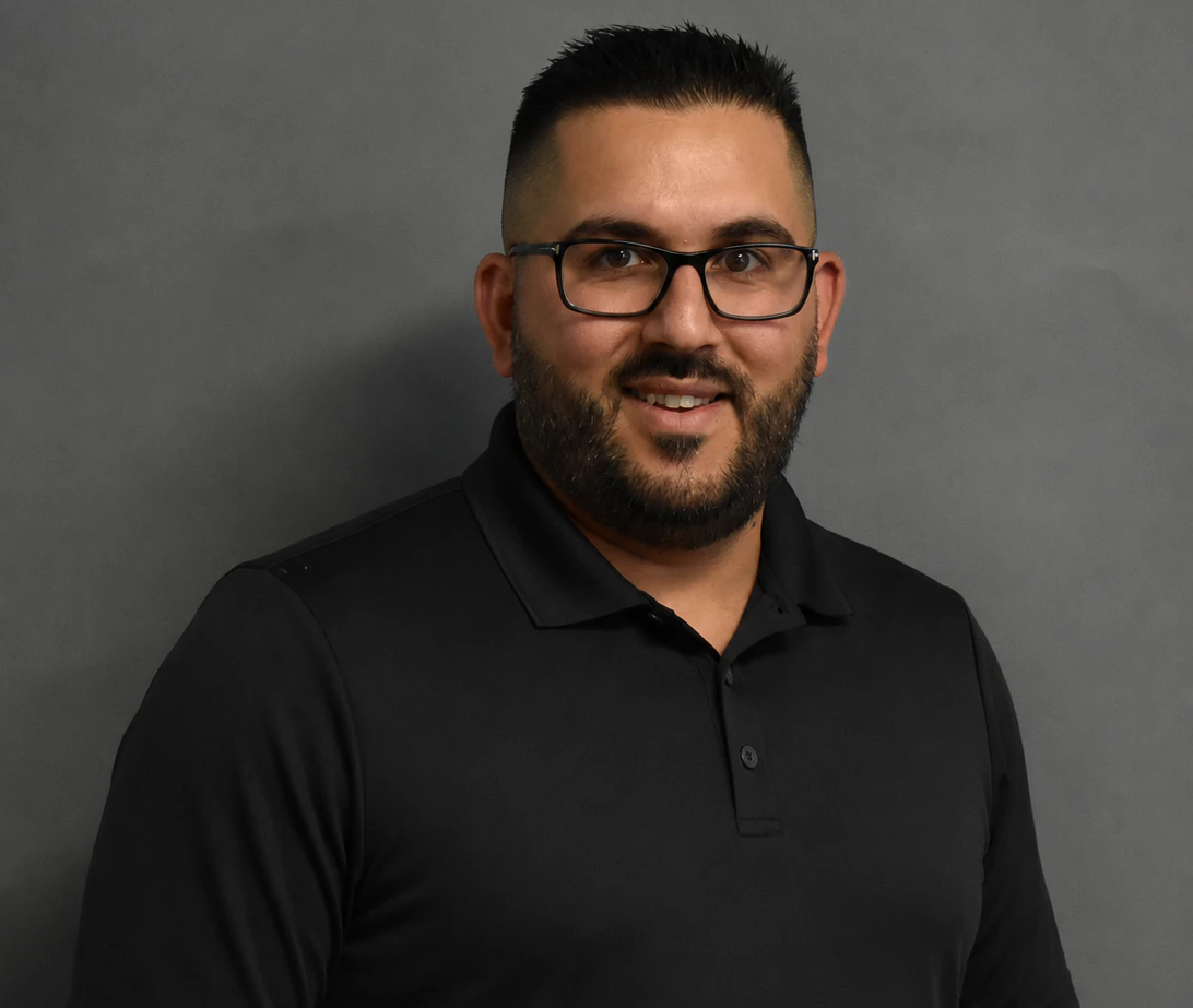Go Auto sales team member smiling wearing black polo shirt and glasses